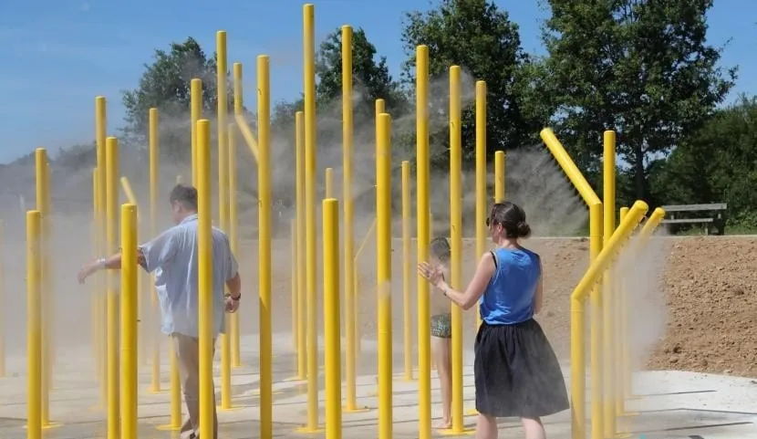 Mâts brumisateurs jaunes sur une aire de jeux