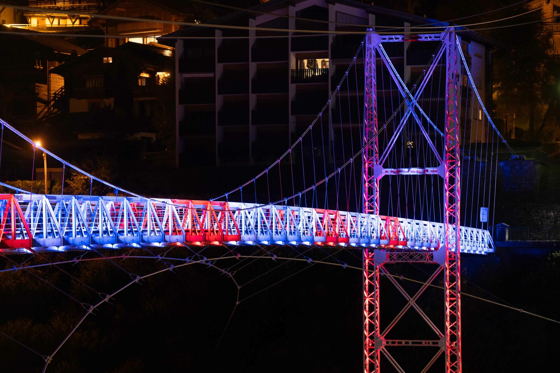 Pont suspendu de Morzine mis en lumière en bleu-blanc-rouge par LEC
