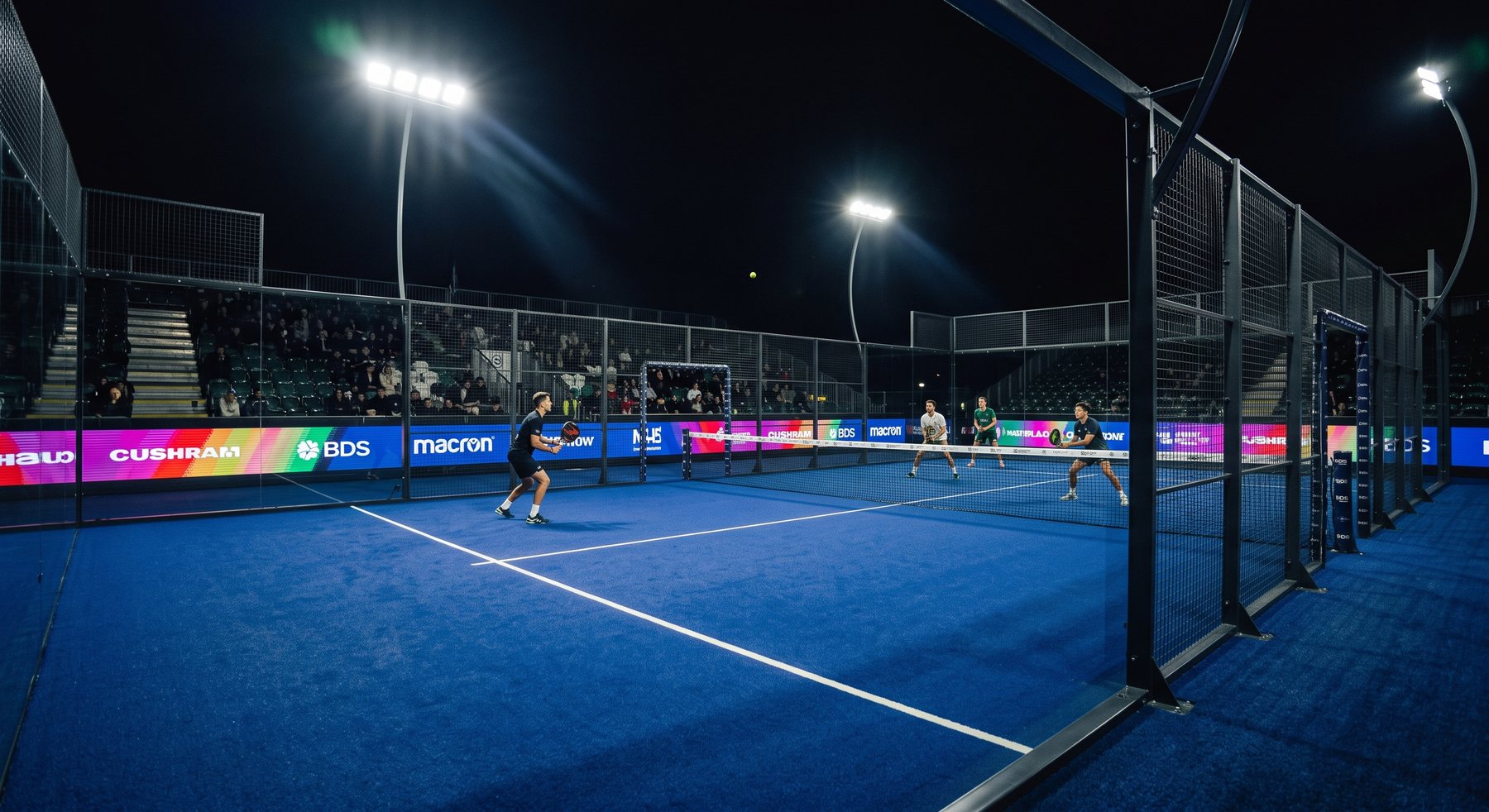 Court de padel bleu éclairé de nuit, match de double devant les tribunes